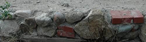 Any rock, concrete, brick, bottle can be used to make a garden wall