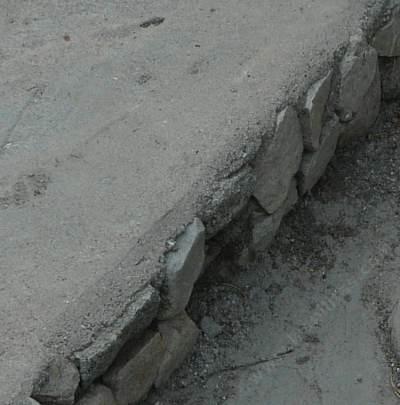 If you need a small wall to hold that patio, frame out the concrete with rocks
